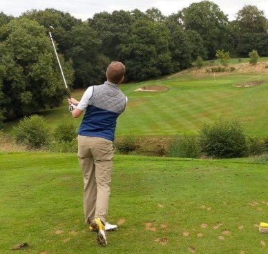 Golfer mid-swing at a Sussex tee